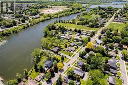 Waterfront properties along a winding river, bordered by established residential areas and abundant green spaces - 
