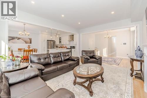Living room with light hardwood / wood-style floors and an inviting chandelier - 53 Mackay Drive, Woodstock, ON - Indoor Photo Showing Living Room