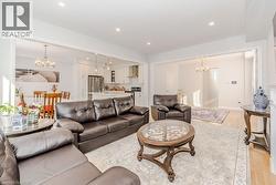Living room with light hardwood / wood-style floors and an inviting chandelier - 