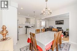 Dining room with light tile patterned floors, an inviting chandelier, and sink - 