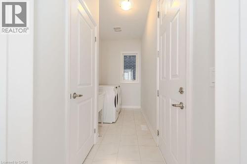 Laundry area with washer and dryer and light tile patterned floors - 53 Mackay Drive, Woodstock, ON - Indoor Photo Showing Other Room
