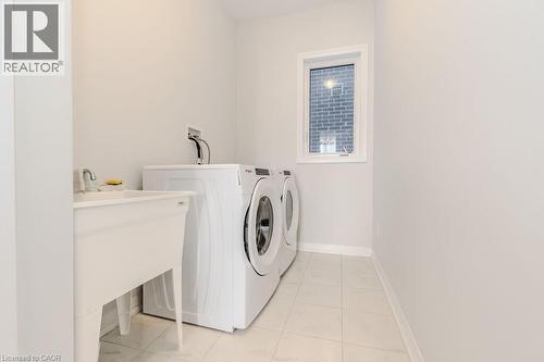 Laundry area with washer and clothes dryer and light tile patterned flooring - 53 Mackay Drive, Woodstock, ON - Indoor Photo Showing Laundry Room