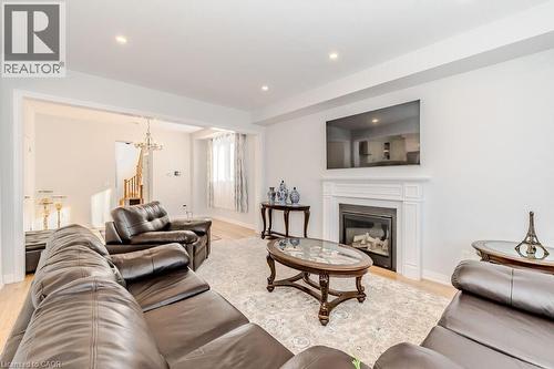 Living room featuring an inviting chandelier and light hardwood / wood-style flooring - 53 Mackay Drive, Woodstock, ON - Indoor Photo Showing Living Room With Fireplace