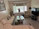 Bright living area featuring wood-finish flooring, a large bay window, and crown molding - 1571 Muir Road, Mississauga, ON 