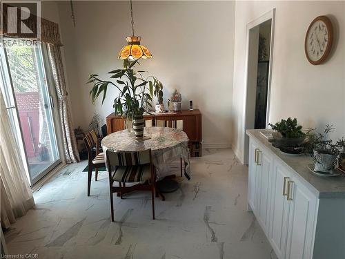 Spacious dining area featuring marble-look tile flooring and white baseboards - 1571 Muir Road, Mississauga, ON 