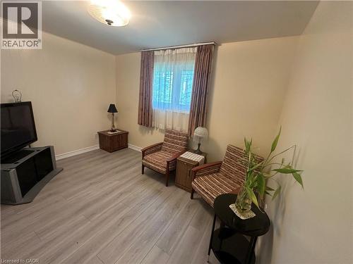 Spacious interior featuring light wood-finish flooring, a window with drapery, and a ceiling-mounted light fixture - 1571 Muir Road, Mississauga, ON 