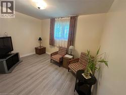 Spacious interior featuring light wood-finish flooring, a window with drapery, and a ceiling-mounted light fixture - 