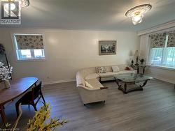 Open concept living space featuring light wood-finish flooring and crown molding - 