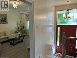 Entryway with a red door, sidelight windows, and a transom window featuring decorative glass - 