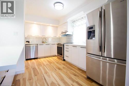 Modern kitchen featuring light wood-finish flooring and white cabinetry - 30 Eastvale Place, Hamilton, ON - Indoor Photo Showing Kitchen