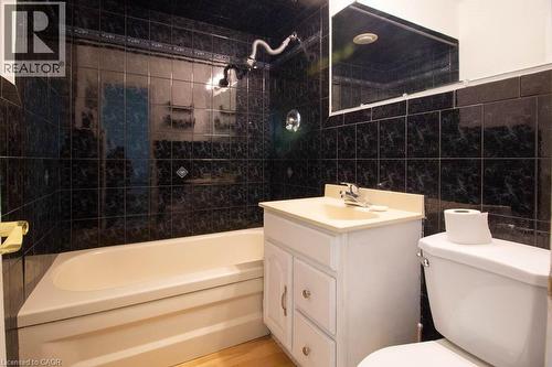 Bathroom featuring a white bathtub, black tile surround, and a chrome shower head - 30 Eastvale Place, Hamilton, ON - Indoor Photo Showing Bathroom