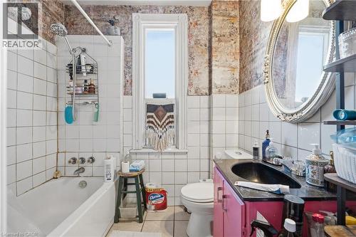 Bathroom featuring white square wall tiling, a white bathtub, and a window with white trim - 355 Barton Street E, Hamilton, ON - Indoor Photo Showing Bathroom