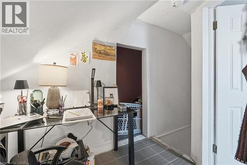 Sloped ceiling room featuring white painted walls and a dark red accent wall - 355 Barton Street E, Hamilton, ON - 