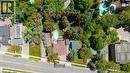 Aerial view of a residential property featuring extensive tree coverage, a brown-roofed structure, and a visible swimming pool - 395 Erb Street, Waterloo, ON 
