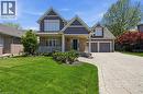 Exterior featuring brick and shingle siding, a covered front porch with white railing, and a two-car garage with individual doors - 56 Mccaffery Crescent, St. Catharines, ON  - Outdoor With Deck Patio Veranda With Facade 