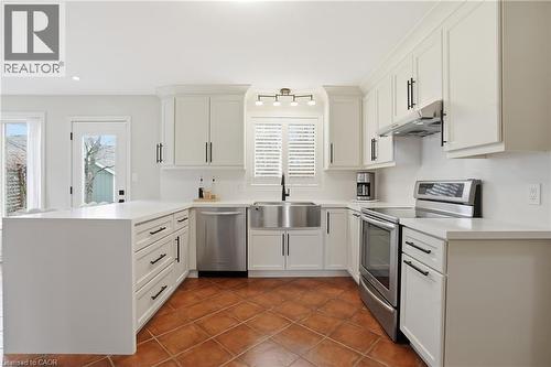 Kitchen featuring stainless steel appliances, white cabinets, a peninsula, dark tile patterned floors, and recessed lighting - 56 Mccaffery Crescent, St. Catharines, ON - Indoor Photo Showing Kitchen With Double Sink With Upgraded Kitchen