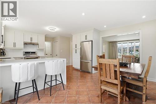 Kitchen featuring stainless steel appliances, a kitchen breakfast bar, white cabinets, a peninsula, and light countertops - 56 Mccaffery Crescent, St. Catharines, ON - Indoor