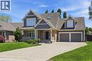 Grey-toned exterior featuring brick and shake siding, a covered front porch, a two-car garage, an interlocking paver driveway, and a dormer window - 56 Mccaffery Crescent, St. Catharines, ON  - Outdoor With Facade 