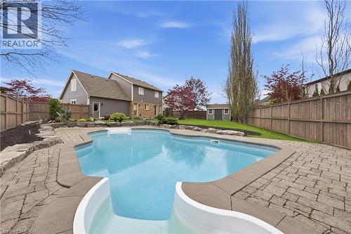 Inviting backyard featuring an in-ground swimming pool with an integrated slide, surrounded by paver stone decking - 56 Mccaffery Crescent, St. Catharines, ON - Outdoor With In Ground Pool With Deck Patio Veranda With Backyard