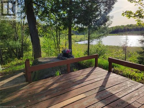 Wood-finish deck overlooking a body of water, surrounded by mature trees and lush greenery - 1006 Hurdville Road, Mckellar, ON - Outdoor With Deck Patio Veranda