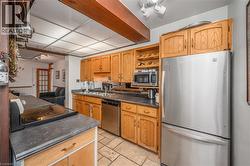 Kitchen featuring wood-finish cabinetry, stainless steel appliances, and stone-finish countertops - 