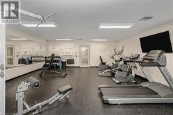 Dedicated fitness room featuring rubberized flooring and extensive wall mirrors - 