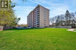Expansive green lawn bordering a multi-story residential building - 