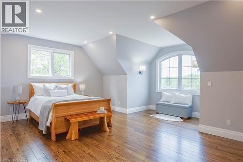 Spacious room featuring wood-finish flooring, recessed lighting, and a prominent arched window - 1521 Emily Lane, Severn, ON - Indoor Photo Showing Bedroom