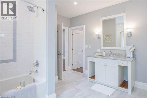 Bathroom featuring a white subway tile shower with a gray accent band, chrome fixtures, and a white vanity with a light-toned countertop - 1521 Emily Lane, Severn, ON - Indoor Photo Showing Bathroom