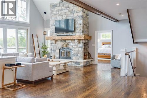 Living area with a floor-to-ceiling stone fireplace, a substantial wood mantel, and a built-in firebox - 1521 Emily Lane, Severn, ON - Indoor Photo Showing Living Room With Fireplace