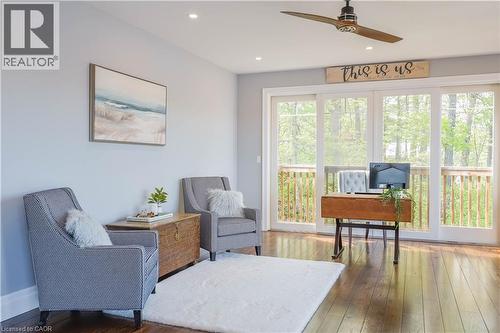 Spacious room featuring rich wood-finish flooring and extensive glass sliding doors opening to an outdoor deck - 1521 Emily Lane, Severn, ON - Indoor