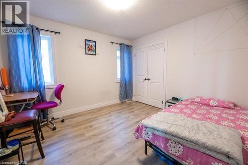 Bright interior space featuring light wood-finish flooring, white walls, and a ceiling-mounted light fixture - 32 Faith Street Unit# 19, Cambridge, ON - Indoor Photo Showing Bedroom