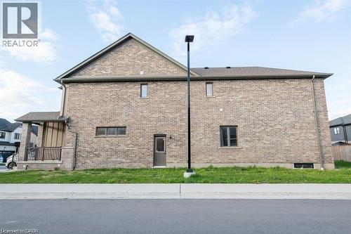 Brick exterior with a covered porch featuring dark railings, a side entry door, and multiple windows - 32 Faith Street Unit# 19, Cambridge, ON - Outdoor