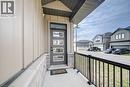 Covered front porch featuring a modern entry door with multiple glass lites, board-and-batten siding, stone facade, and a dark railing - 32 Faith Street Unit# 19, Cambridge, ON  - Outdoor 