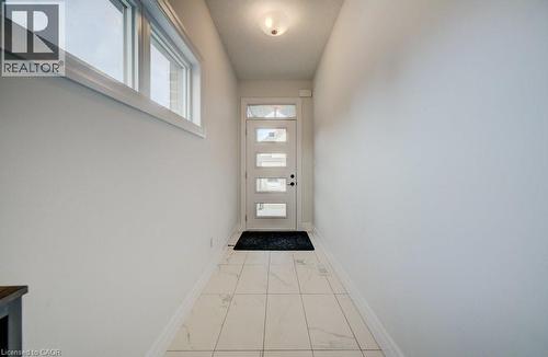 Entryway featuring large format tile flooring, a contemporary door with multiple glass lites, a transom window, and white trim - 32 Faith Street Unit# 19, Cambridge, ON - Indoor Photo Showing Other Room