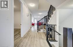 Hallway featuring wood-finish flooring, white walls, and recessed lighting - 