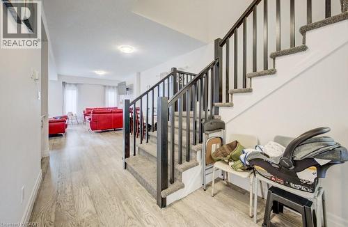 Open-concept main level featuring wood-finish flooring, a carpeted staircase with dark balusters, and recessed lighting - 32 Faith Street Unit# 19, Cambridge, ON - Indoor Photo Showing Other Room