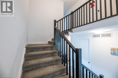 Carpeted staircase with dark wood-finish newel posts and spindles - 32 Faith Street Unit# 19, Cambridge, ON - Indoor Photo Showing Other Room
