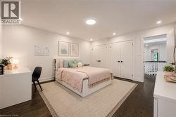 Spacious room featuring dark wood-finish flooring, recessed lighting, and a contemporary ceiling fixture - 