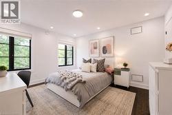 Bedroom featuring dark wood-finish flooring, white walls, and recessed lighting - 