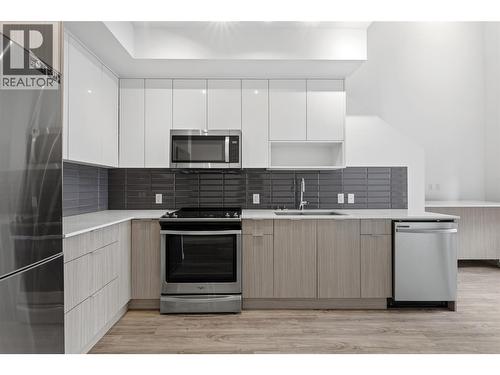 Gourmet kitchen featuring quartz countertops, sleek cabinetry, and stainless steel appliances. - 1775 Chapman Place Unit# 101, Kelowna, BC - Indoor Photo Showing Kitchen With Stainless Steel Kitchen With Upgraded Kitchen