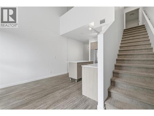 Architectural staircase leading to the private loft-style primary retreat. - 1775 Chapman Place Unit# 101, Kelowna, BC - Indoor Photo Showing Other Room