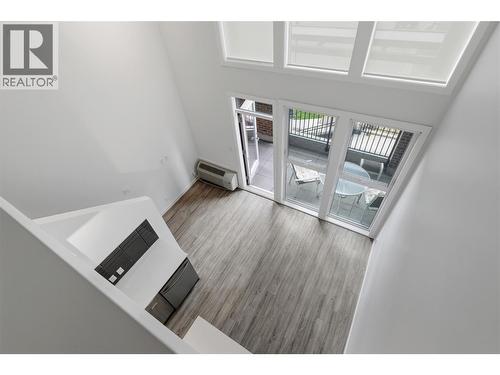 Dramatic two-storey living room with soaring ceilings and abundant natural light. - 1775 Chapman Place Unit# 101, Kelowna, BC - Indoor Photo Showing Other Room