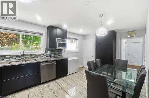 Kitchen space featuring dark cabinetry, stainless steel dishwasher, and a double basin sink - 158 Plymouth Road, Kitchener, ON - Indoor Photo Showing Kitchen With Double Sink