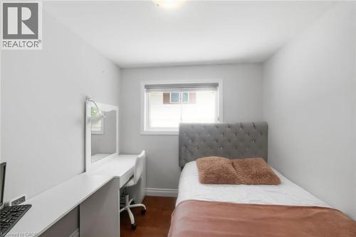 Bright room featuring wood-finish flooring, a contemporary window with blinds, and a built-in desk area - 158 Plymouth Road, Kitchener, ON - Indoor Photo Showing Bedroom