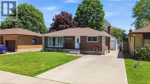 Brick and stone exterior featuring a covered entry, black wrought iron railing, and a concrete driveway - 158 Plymouth Road, Kitchener, ON - Outdoor With Facade