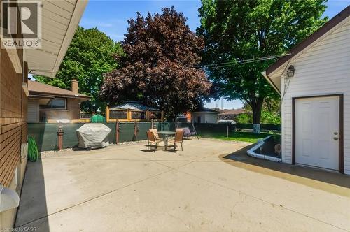 Expansive concrete patio area with brick exterior and white vinyl siding - 158 Plymouth Road, Kitchener, ON - Outdoor With Exterior