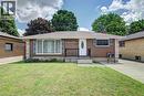 Brick exterior featuring stone accents, a front porch with black railing, a paved driveway, and a front lawn - 158 Plymouth Road, Kitchener, ON 