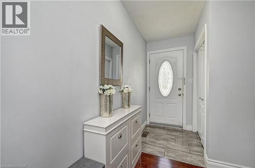 Entryway featuring a white door with an oval decorative glass insert, complemented by light gray wall paint - 158 Plymouth Road, Kitchener, ON 