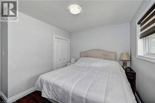 Interior room featuring wood-finish flooring, light-toned walls, and a window with a roller shade - 158 Plymouth Road, Kitchener, ON 